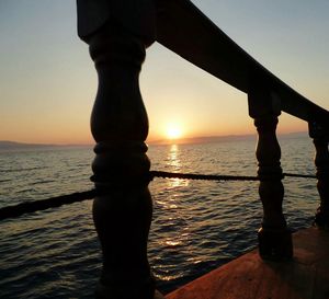 Silhouette of pier against calm sea at sunset
