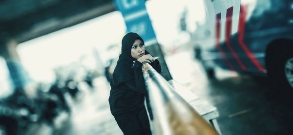 Woman looking at camera while standing on mobile phone