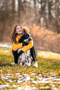 Portrait of woman with dog on field