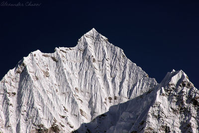 Low angle view of snowcapped mountain against clear sky