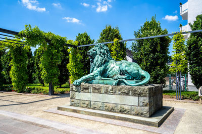 Statue in park against blue sky