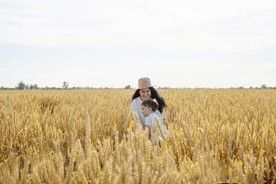 Portrait of woman standing on field against sky