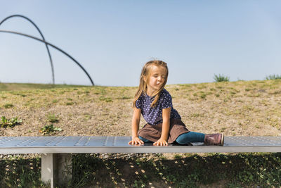 Full length portrait of smiling girl against clear sky