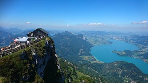 Panoramic view of buildings and mountains against blue sky