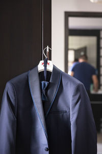 Blazer hanging on handle of cupboard at home