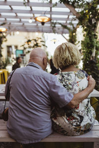 Rear view of senior man and woman sitting in cafe during weekend