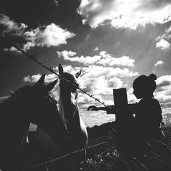 Silhouette of people against cloudy sky