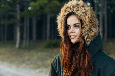 Young woman wearing fur hat while standing outdoors