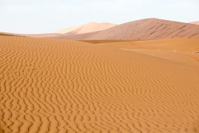 Sand dunes in desert against sky