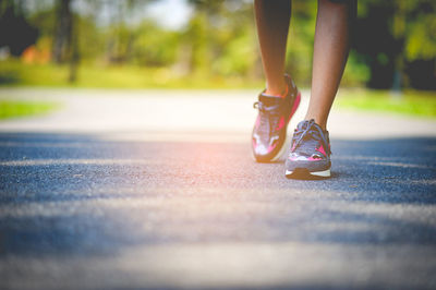 Low section of woman standing on road