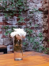 Flower vase on table against wall