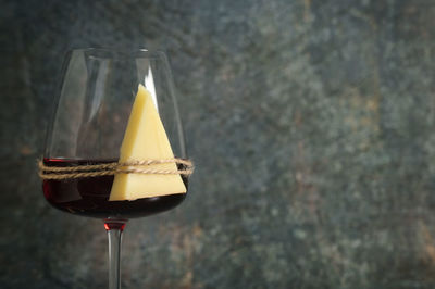 Dry glass of red wine and cheese on stone background