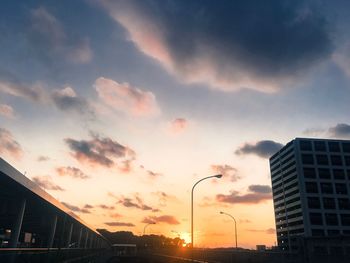 Modern cityscape against sky during sunset