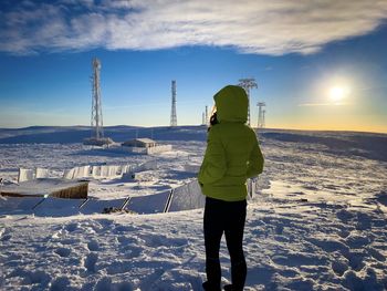 Rear view of man standing on snow covered landscape