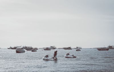 Boats in sea against clear sky