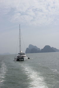Sailboat sailing on sea against sky