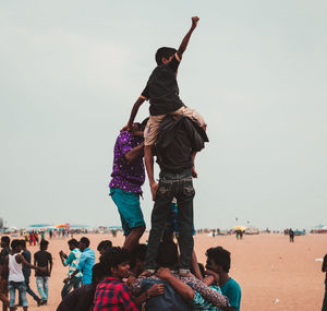 People enjoying at beach against clear sky