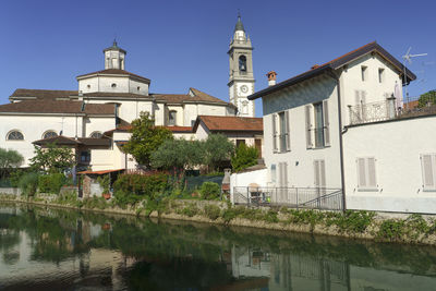 Canal by buildings against sky