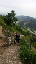 Rear view of people on mountain against sky