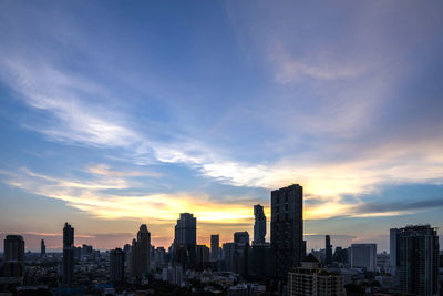 Modern buildings against sky during sunset