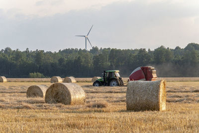 Hay bales on field against sky