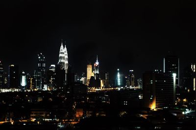 Illuminated cityscape against sky at night