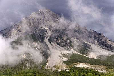 Scenic view of rocky mountain at dolomites during foggy weather