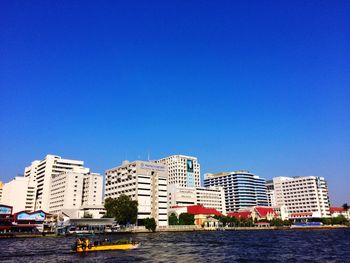 View of cityscape against clear blue sky