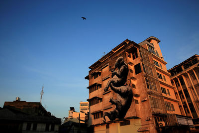 Low angle view of building against clear blue sky