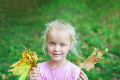 Portrait of a smiling girl holding plant