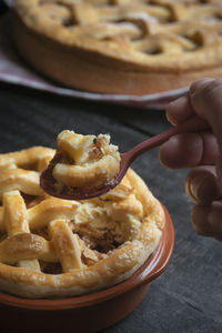 Cropped hand holding pie using spoon