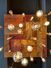 Low angle view of illuminated light bulb hanging on table at home