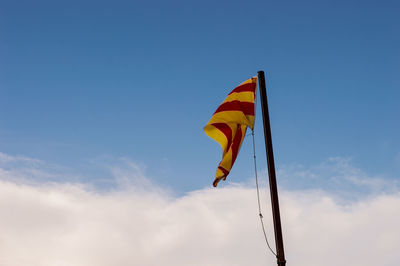 Low angle view of flag against blue sky