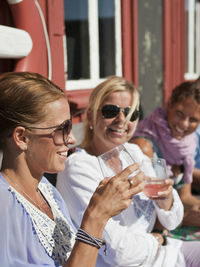 Three women resting in front of boathouse