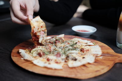 Hand take crispy pizza at cafe