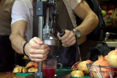 Man preparing pomegranate juice at counter