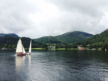 Scenic view of lake and mountains against cloudy sky