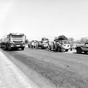 Vehicles on road against clear sky