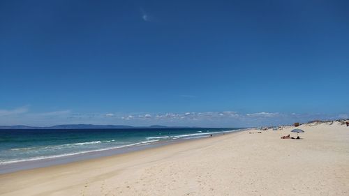 Scenic view of beach against blue sky