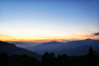 Scenic view of silhouette mountains against sky at sunset