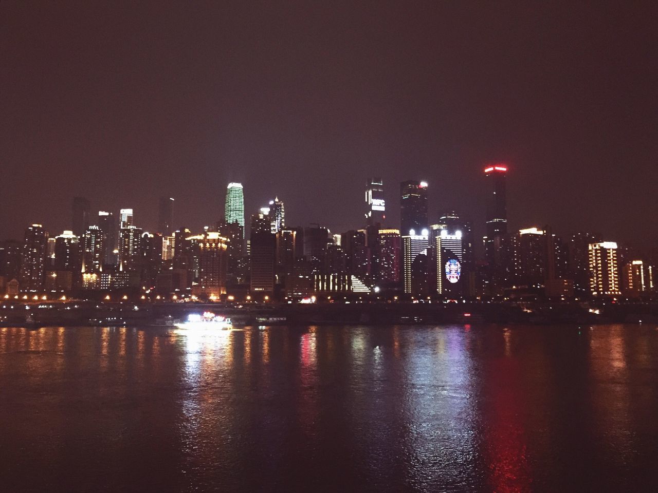 city, illuminated, architecture, building exterior, night, built structure, water, waterfront, cityscape, skyscraper, reflection, river, urban skyline, modern, office building, clear sky, tower, tall - high, city life, sky