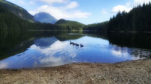 Scenic view of lake by mountains against sky