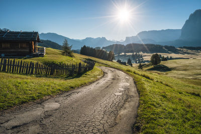 Road amidst field against sky