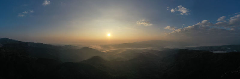 Panoramic aerial landscape view morning sunlight blue sky and mountain range with fog in valley 