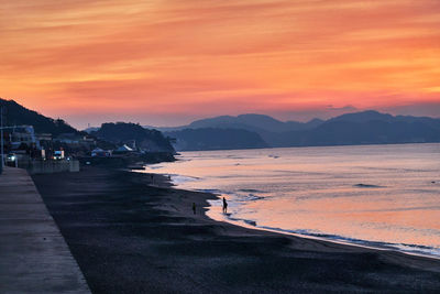 Scenic view of sea against orange sky during sunrise