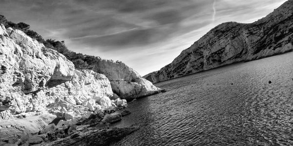 Rock formations by sea against sky