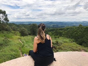 Rear view of woman on landscape against sky