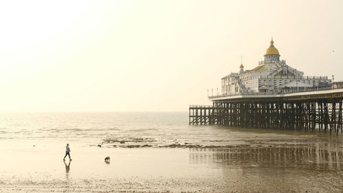 View of building on beach against clear sky