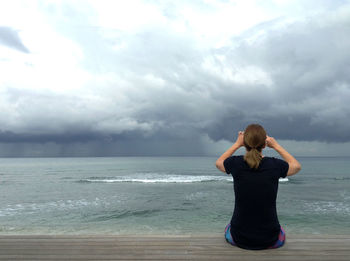 Rear view of young woman standing on beach