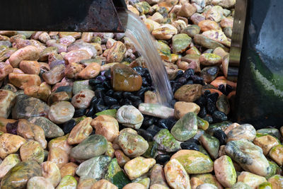 High angle view of pebbles in container at market stall